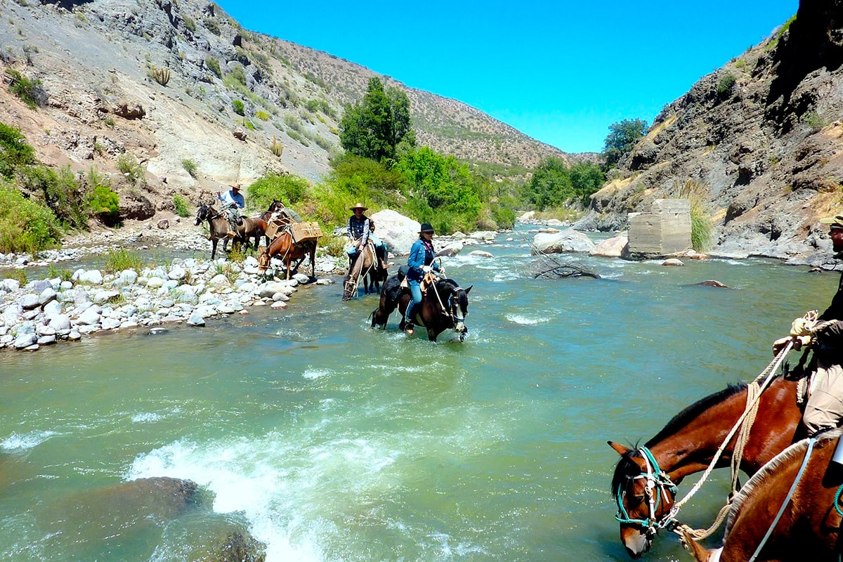 Überqueren Sie den Fluss zu Pferd in den Anden